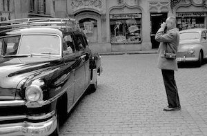 Henri Cartier-Bresson sembra fotografare un auto lussuosa di passaggio